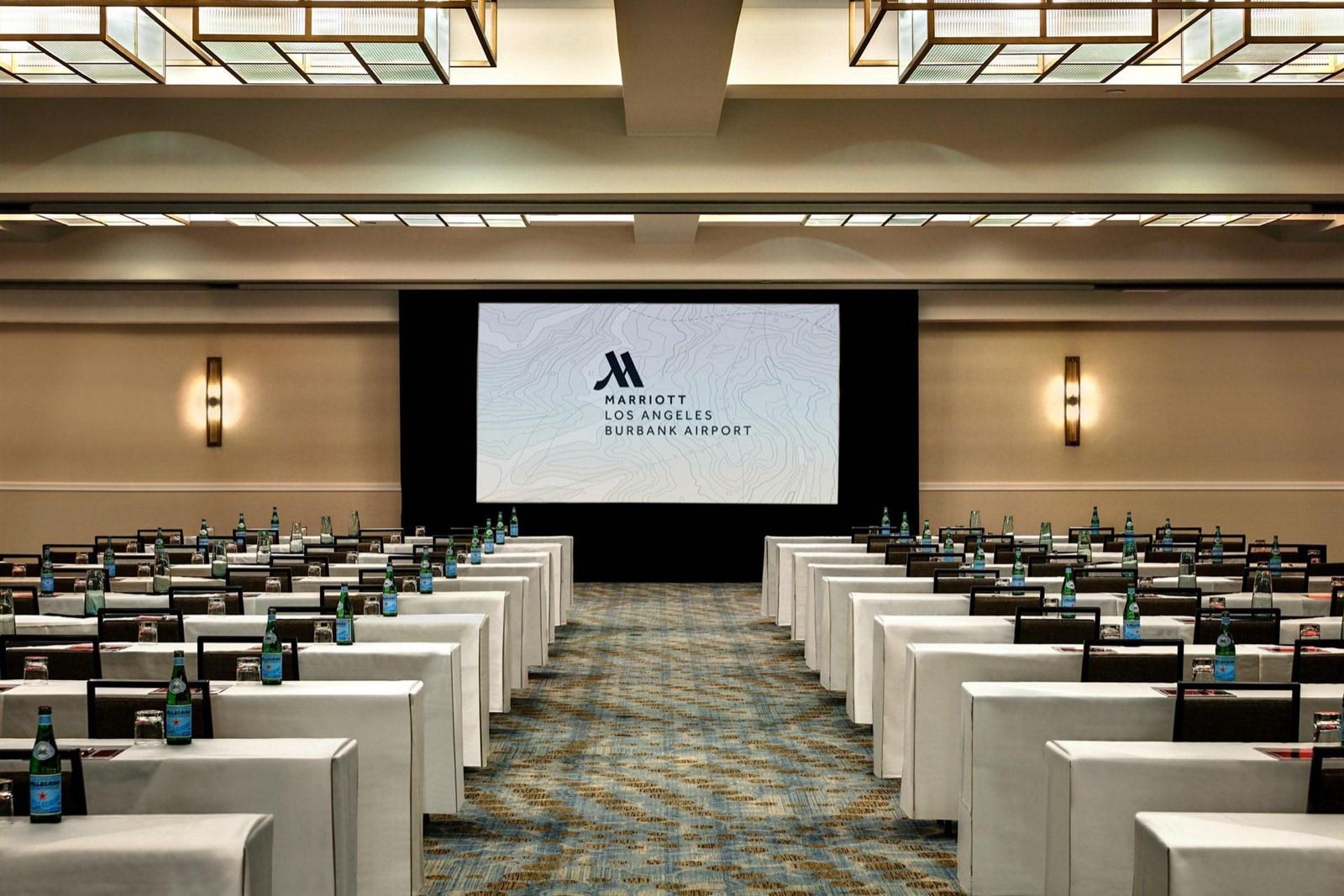 City Ballroom in classroom set with draped tables facing a widescreen