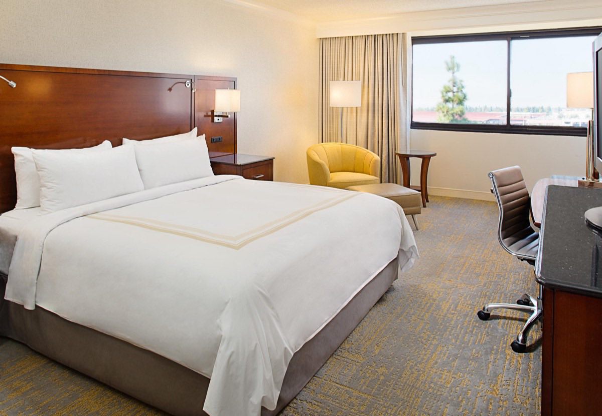 King guest room with warm wood headboard and a window over Burbank